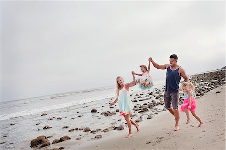 Parents and two young girls walking on beach Foto de stock - Sin royalties Premium, Código: 614-07444317
