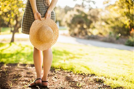 debajo de la cintura - Cropped image of teenage girl holding sunhat behind her back Foto de stock - Sin royalties Premium, Código: 614-07444334
