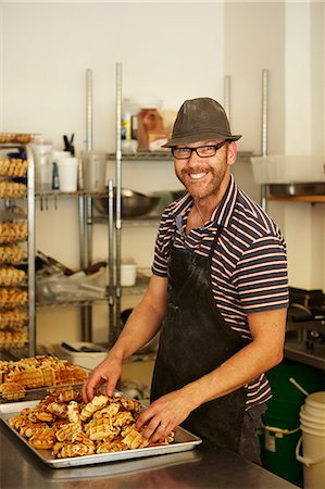 delicious food - Male baker with tray of waffles in bakery Photographie de stock - Premium Libres de Droits, Code: 614-07453230