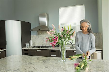 picture of mature in kitchen - Woman arranging lilies Stock Photo - Premium Royalty-Free, Code: 614-07453265