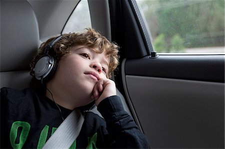 road trip technology - Boy in back seat of car, wearing headphones Stock Photo - Premium Royalty-Free, Code: 614-07453263