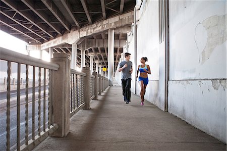 sidewalk - Young couple running on city bridge Stock Photo - Premium Royalty-Free, Code: 614-07453279