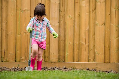 fence home - Young girl digging soil in the garden Stock Photo - Premium Royalty-Free, Code: 614-07486905