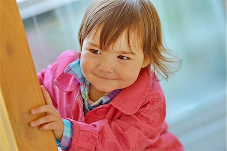 simsearch:614-06043444,k - Female toddler peeking from a wooden post Photographie de stock - Premium Libres de Droits, Code: 614-07486912