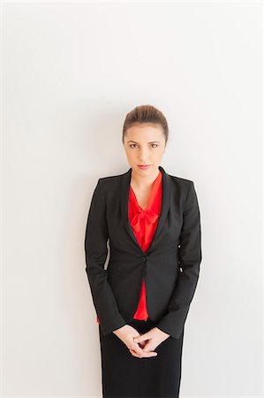 Portrait of young businesswoman in front of white office wall Stock Photo - Premium Royalty-Free, Code: 614-07487005