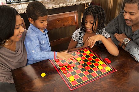 Mid adult couple and children playing draughts at dining table Foto de stock - Sin royalties Premium, Código: 614-07487014