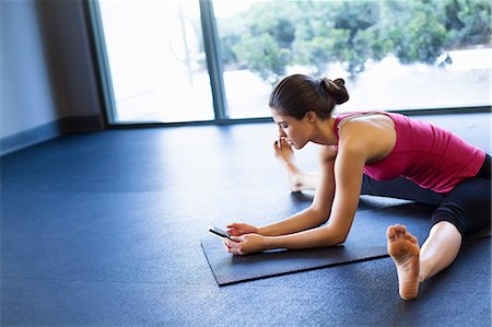 flexible - Young woman in yoga posture using cellular phone Foto de stock - Sin royalties Premium, Código: 614-07487127