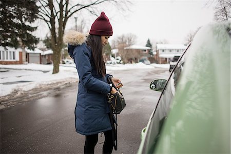 Young woman searching for car keys in her bag Stock Photo - Premium Royalty-Free, Code: 614-07487137