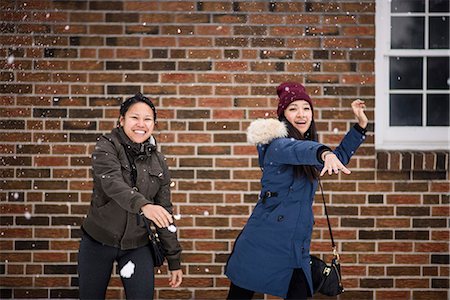 Two you adult females throwing snowballs Stock Photo - Premium Royalty-Free, Code: 614-07487138