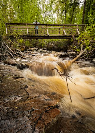 Young man on river footbridge, Naramata, British Columbia, Canada Stock Photo - Premium Royalty-Free, Code: 614-07487157