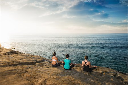 simsearch:614-07487185,k - Women sitting on cliff top, looking at sea and meditating Foto de stock - Sin royalties Premium, Código: 614-07487187