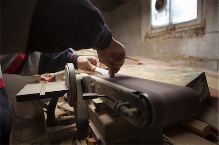 sciure - Close up of mature man using sanding belt in workshop Photographie de stock - Premium Libres de Droits, Code: 614-07487242