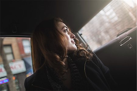 Young woman looking over her shoulder from taxi Stock Photo - Premium Royalty-Free, Code: 614-07487256