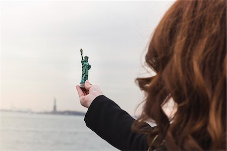 statue de la liberté - Young woman holding statue of liberty souvenir, New York, USA Photographie de stock - Premium Libres de Droits, Code: 614-07487259