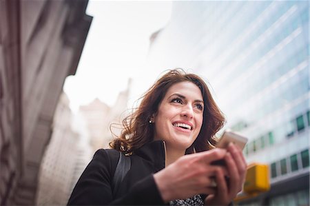 Young woman holding cellphone, New York, USA Stock Photo - Premium Royalty-Free, Code: 614-07487262