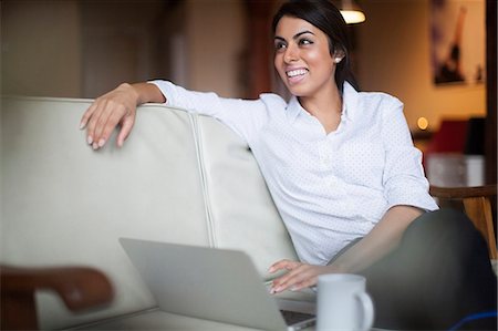 female and twenties and sitting - Young woman using laptop computer Stock Photo - Premium Royalty-Free, Code: 614-07487277