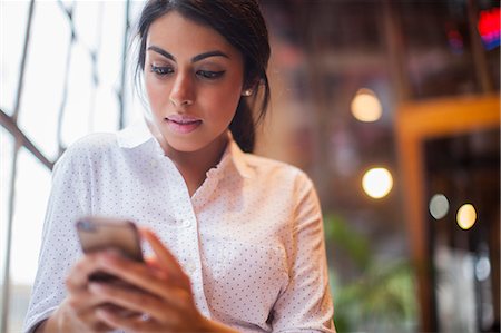 people looking down smart phones - Young woman using smartphone Stock Photo - Premium Royalty-Free, Code: 614-07487280