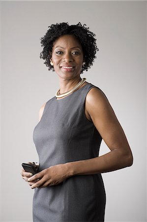 portrait studio smile - Businesswoman holding smartphone Stock Photo - Premium Royalty-Free, Code: 614-07487290