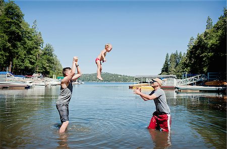 Female toddler thrown and caught mid air by young men Photographie de stock - Premium Libres de Droits, Code: 614-07587561