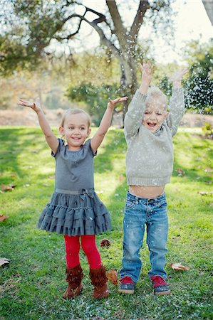 Brother and sister with arms raised, in garden Stock Photo - Premium Royalty-Free, Code: 614-07587630