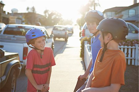street suburb - Boys wearing helmets talking Photographie de stock - Premium Libres de Droits, Code: 614-07652255