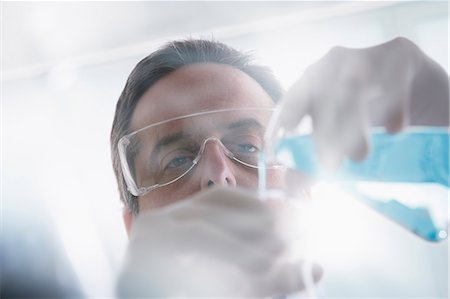 simsearch:614-07652261,k - Scientist pouring liquid into test tube Foto de stock - Sin royalties Premium, Código: 614-07652257