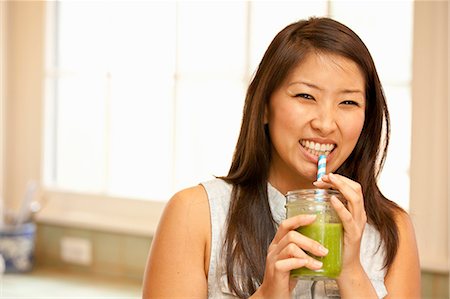 drinking - Young woman sipping green smoothie Foto de stock - Sin royalties Premium, Código: 614-07652323
