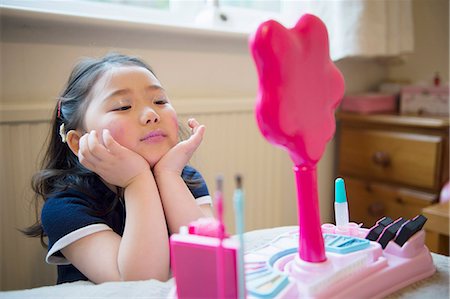 Girl putting make up on Stock Photo - Premium Royalty-Free, Code: 614-07652342