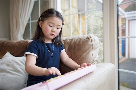 Girl playing toy keyboard Stock Photo - Premium Royalty-Free, Code: 614-07652343