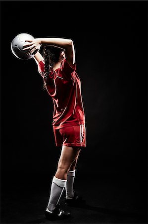 female fitness studio shot - Young woman throwing football Stock Photo - Premium Royalty-Free, Code: 614-07652388