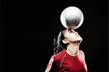 football skill - Young woman balancing football on forehead Stock Photo - Premium Royalty-Free, Code: 614-07652390