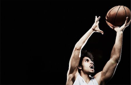 portrait black background - Basketball player catching basketball Stock Photo - Premium Royalty-Free, Code: 614-07652425