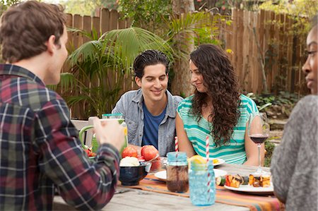 Friends sitting around table sharing barbecue food Foto de stock - Sin royalties Premium, Código: 614-07652467