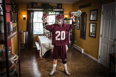 Teenage boy wearing lacrosse uniform, standing in dining room Photographie de stock - Premium Libres de Droits, Code: 614-07652485