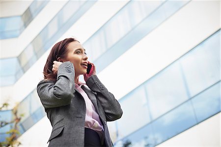 simsearch:649-07560135,k - Young female businesswoman talking on smartphone outside office Stock Photo - Premium Royalty-Free, Code: 614-07652566