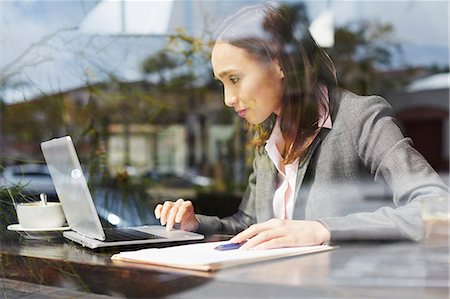 Young female businesswoman using laptop in cafe Stock Photo - Premium Royalty-Free, Code: 614-07652562