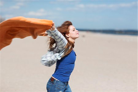 Young woman holding up blanket on windy beach Photographie de stock - Premium Libres de Droits, Code: 614-07708177