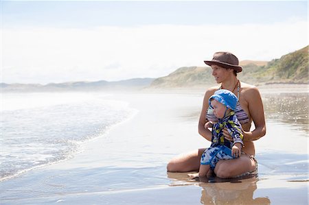 Young woman sitting on beach with baby son Stock Photo - Premium Royalty-Free, Code: 614-07708268