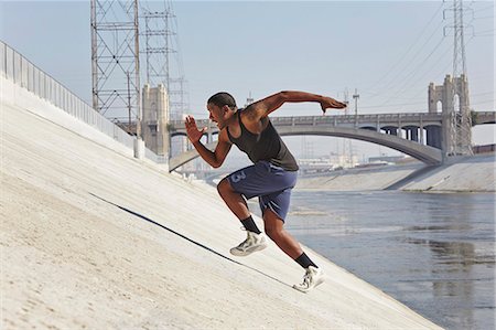 side pose - Young man speed running up riverbank Stock Photo - Premium Royalty-Free, Code: 614-07708262