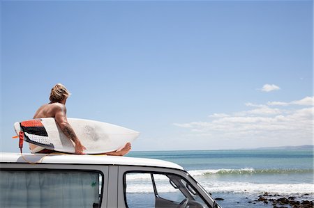 picture of a middle aged man on a surf board - Mature male surfer watching from vehicle roof at beach Stock Photo - Premium Royalty-Free, Code: 614-07708272