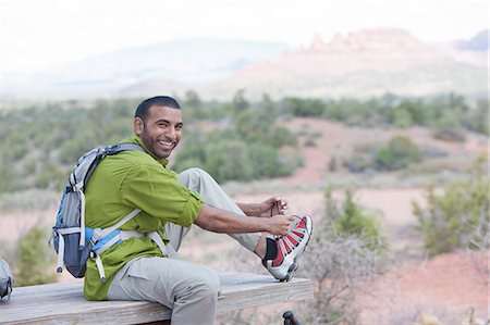 sedona - Portrait of young male hiker tying shoelaces, Sedona, Arizona, USA Fotografie stock - Premium Royalty-Free, Codice: 614-07708335