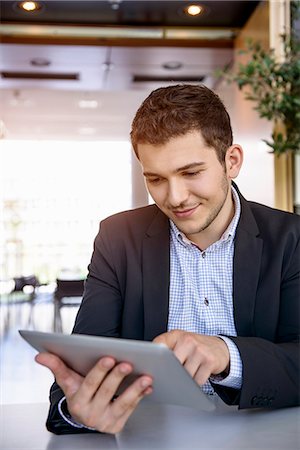 successful businessman - Young man in office using touchscreen on digital tablet Photographie de stock - Premium Libres de Droits, Code: 614-07735226