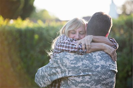 family photo usa - Male soldier hugging mother on street at homecoming Stock Photo - Premium Royalty-Free, Code: 614-07735257