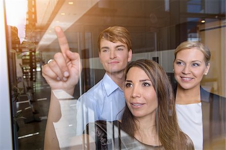 Businesswoman pointing out of glass window to colleagues Stockbilder - Premium RF Lizenzfrei, Bildnummer: 614-07735322