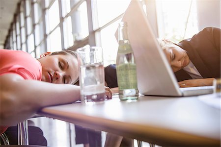 sleeping on boardroom table - Businesswomen exhausted at brainstorm meeting Stock Photo - Premium Royalty-Free, Code: 614-07735344