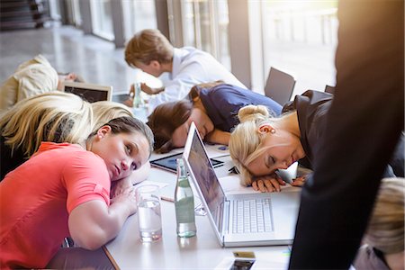 Businessmen and businesswomen exhausted at brainstorm meeting Stock Photo - Premium Royalty-Free, Code: 614-07735343