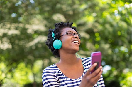 simsearch:614-07652557,k - Young woman in park listening and singing to music on headphones Stock Photo - Premium Royalty-Free, Code: 614-07735377