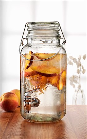 pote de mantimentos - Glass jar with tap dispenser containing fresh peach drink Foto de stock - Royalty Free Premium, Número: 614-07735371
