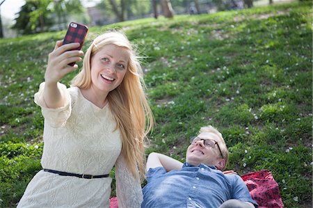 simsearch:614-08392622,k - Young couple taking selfie with smartphone in park Photographie de stock - Premium Libres de Droits, Code: 614-07735420