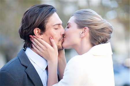 Businessman and woman kissing on city street Stock Photo - Premium Royalty-Free, Code: 614-07735484